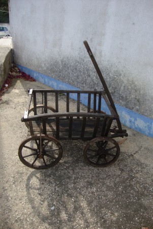 Carroça de lenha ou para caça. Peça em madeira e ferro para ser puxada por pessoa ou animal de pequeno porte.