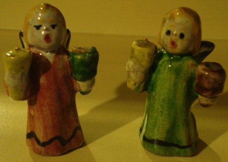 Par de miniaturas de anjos natalicios. Falta a asa de uma das figuras. São em barro multicolor e vidrado. Têm 6,5cm de altura. 