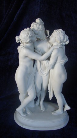 Grupo escultórico " Três Graças" em Biscuit Francês, cópia da escultura de António Cánova. Peça do séc. XIX. Apresenta um dedo colado. Tem cerca de 23cm de altura. 